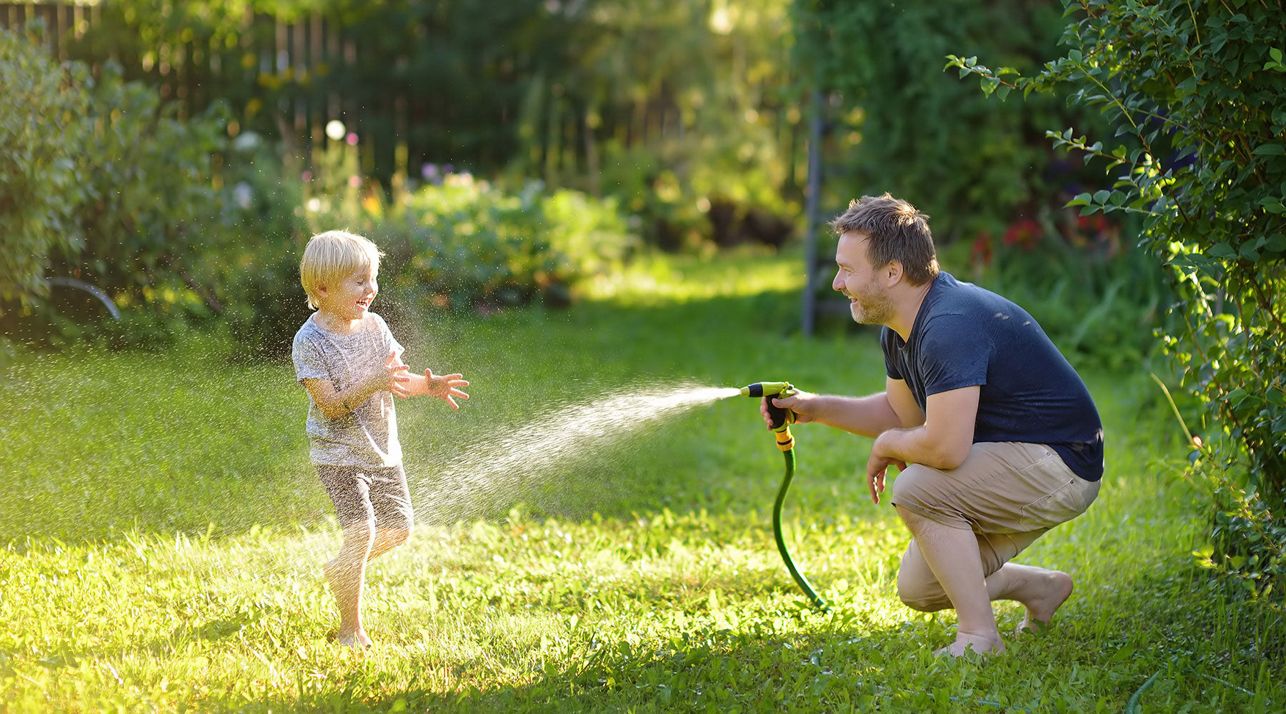 Junge spielt mit seinem Vater im Garten - auf einem gut gepflegten Rasen macht das besonders Spaß.